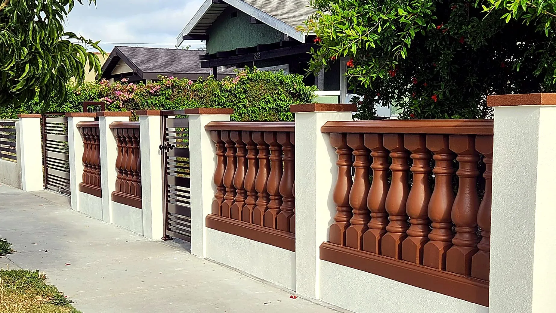 Concrete balustrade fence painted brown with white stucco pillars