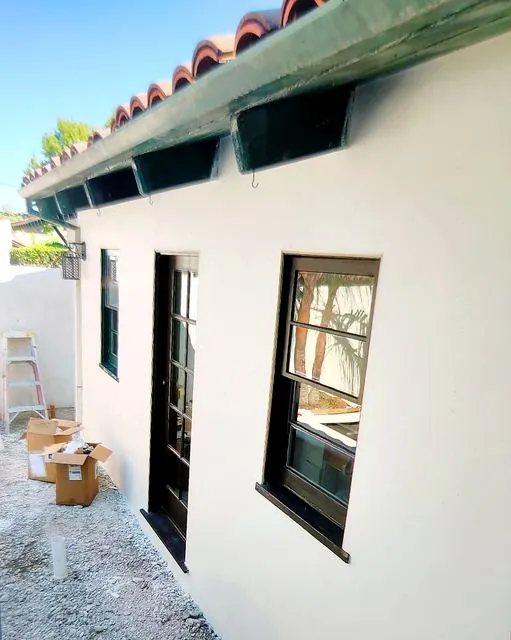Smooth white stucco wall with black-framed windows