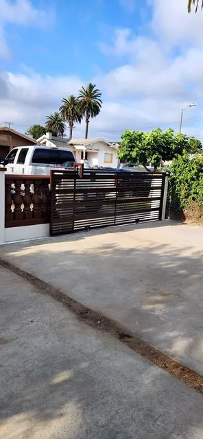 Brown horizontal-slat metal driveway gate